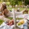 Lifestyle photo of a man and a woman sitting on a blanket in a grassy area