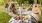 Lifestyle photo of a man and a woman sitting on a blanket in a grassy area