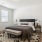 Modern furnished bedroom with a bed and a bench in townhome at The Harris