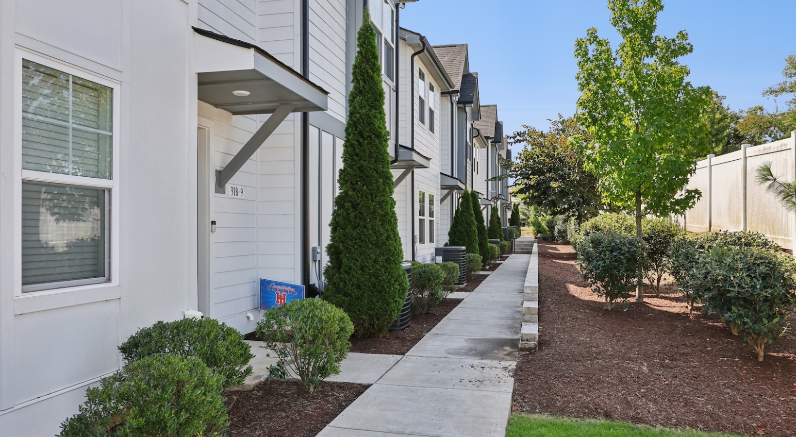 a row of houses with trees in front